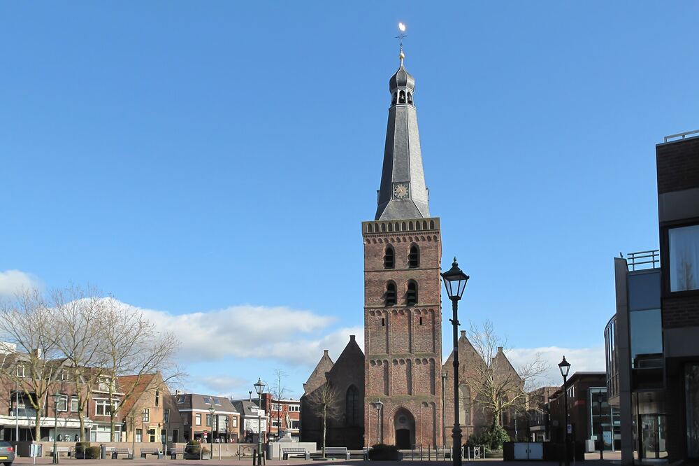 De markante toren van de Oude Kerk aan het Torenplein in het centrum van Barneveld onder een blauwe lucht